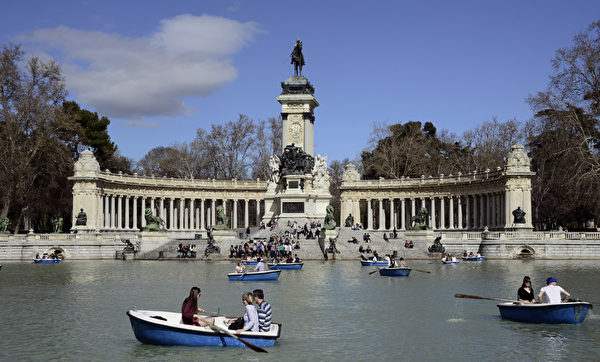 People row rented boats on the artificial lake in Madrid's Retiro Park in on March 27, 2015. AFP PHOTO/ GERARD JULIEN