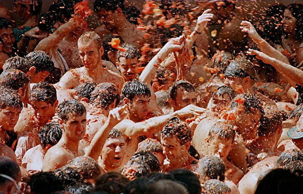 People fight during the traditional tomato battle in Bugnol, Eastern Spain, 27 August. Every year thousands take part in the "Tomatina" festival during which some 125, 000 kilos of tomato are used as projectiles.