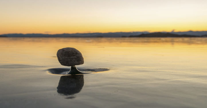“贝加尔湖禅”是贝加尔湖结冰湖面上的细小冰柱支撑石头，却能保持平衡的自然现象。（Shutterstock）