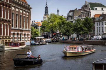 Passengers ride on a tour boat along a canal in Amsterdam on June 17, 2022, as a heatwave spreads across Europe. - - Netherlands OUT (Photo by Remko de Waal / ANP / AFP) / Netherlands OUT (Photo by REMKO DE WAAL/ANP/AFP via Getty Images)