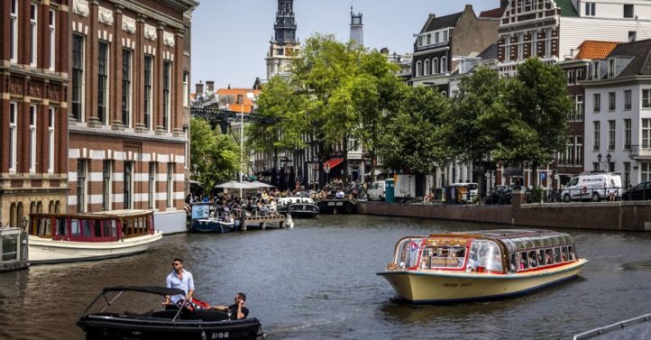 Passengers ride on a tour boat along a canal in Amsterdam on June 17, 2022, as a heatwave spreads across Europe. - - Netherlands OUT (Photo by Remko de Waal / ANP / AFP) / Netherlands OUT (Photo by REMKO DE WAAL/ANP/AFP via Getty Images)